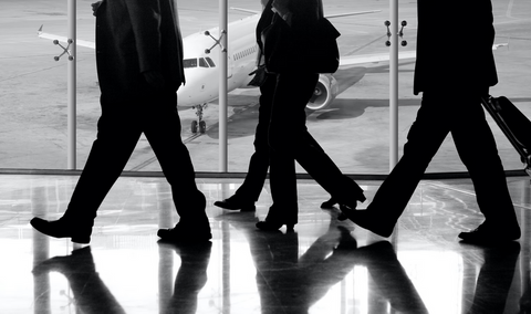 Employees at the airport discussing how Payhawk's virtual cards simplified their business travel expense workflows